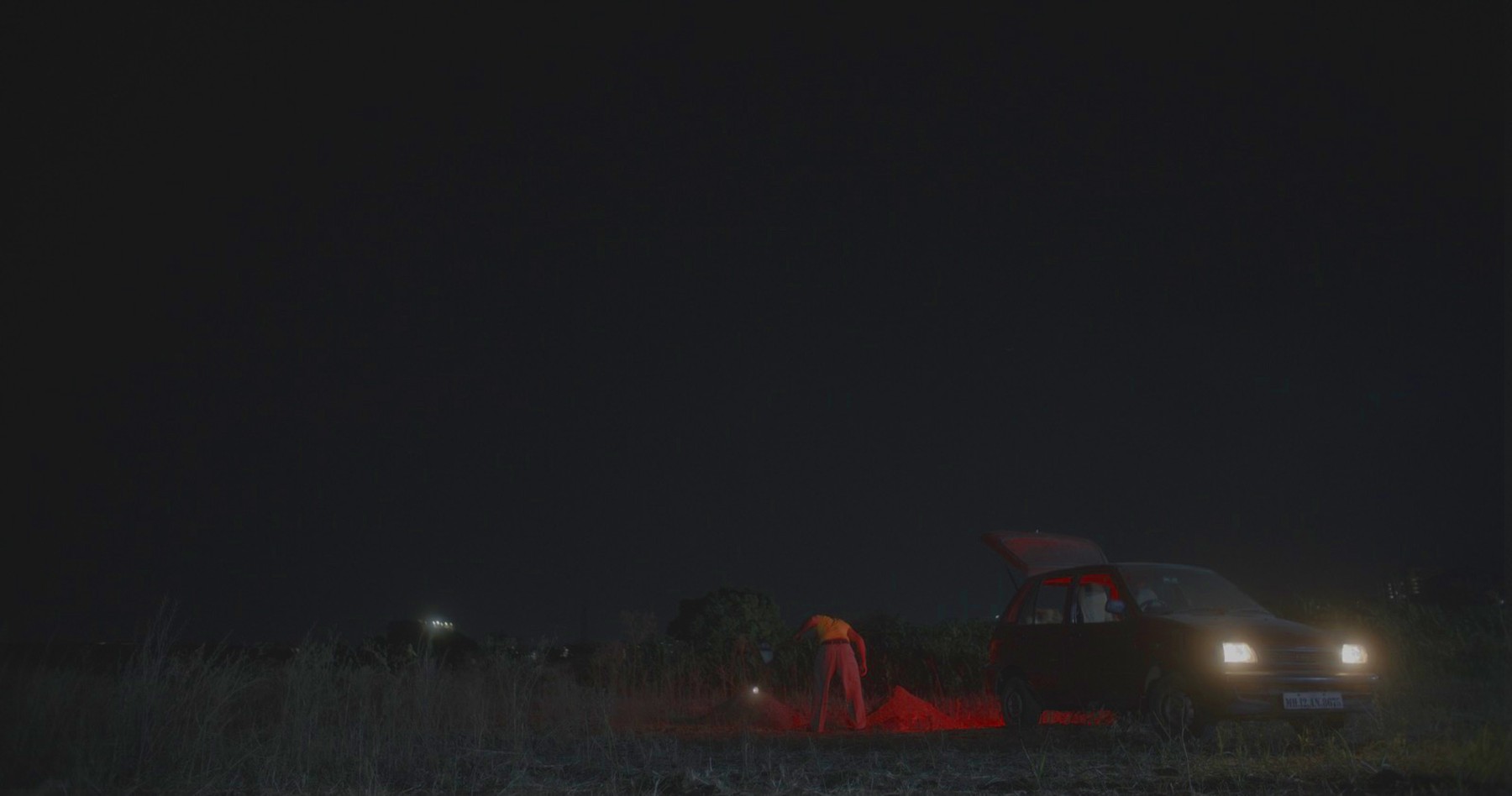 Figure at a car at night, still from Another Short Film About Killing
