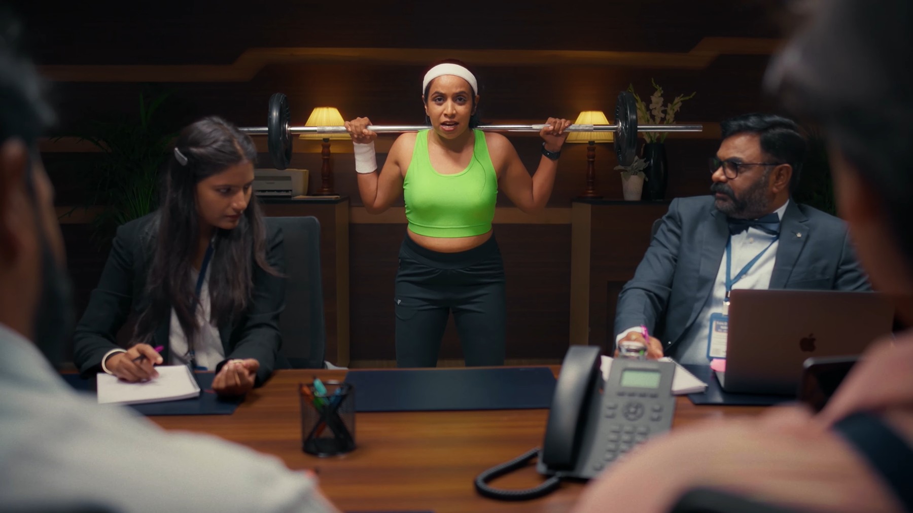 Woman lifting a barbell in the boardroom, FITREATcouple campaign