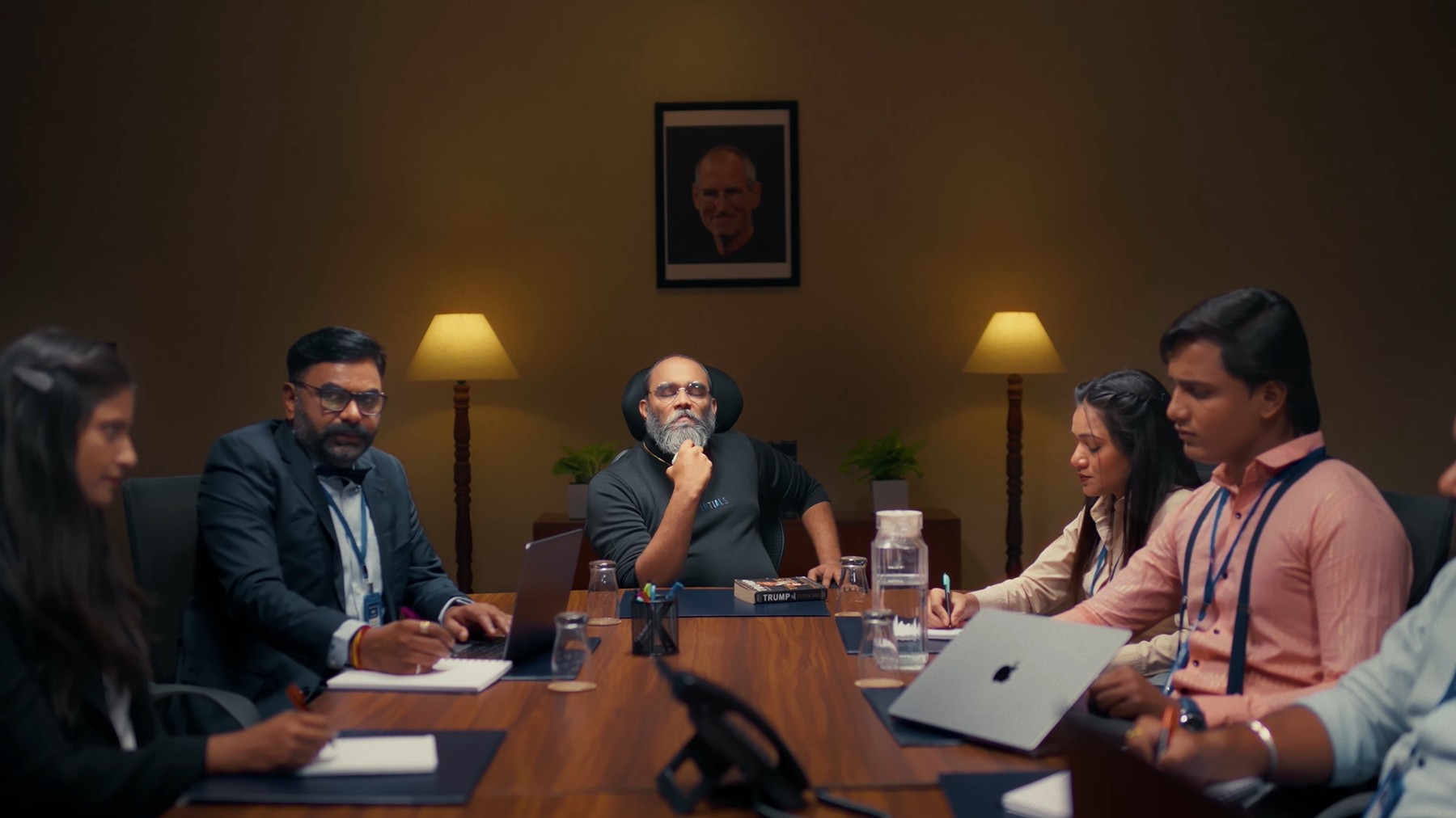 Boss seated beneath a framed portrait, FITREATcouple campaign