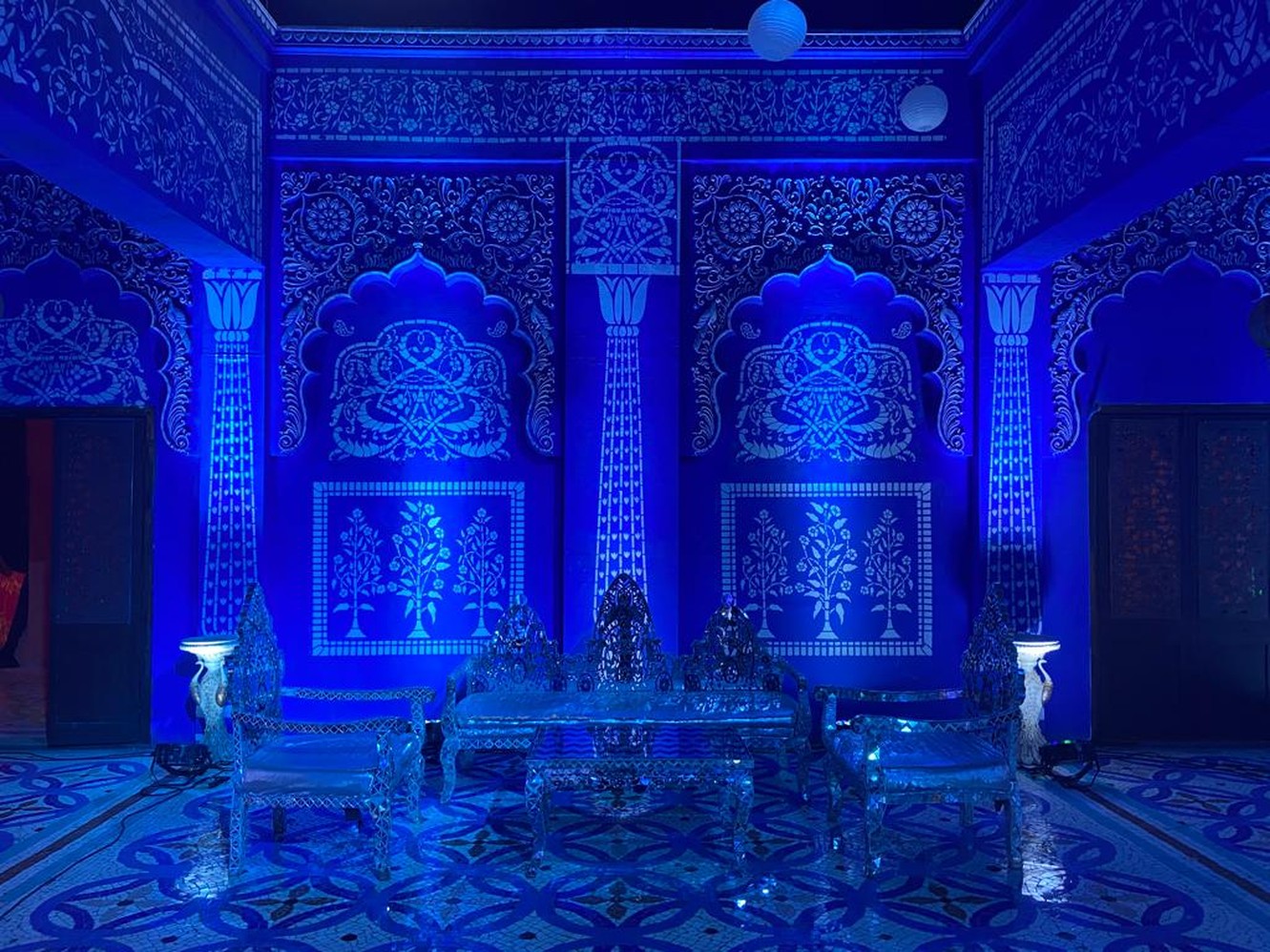 Blue-lit seating area with carved wall panels