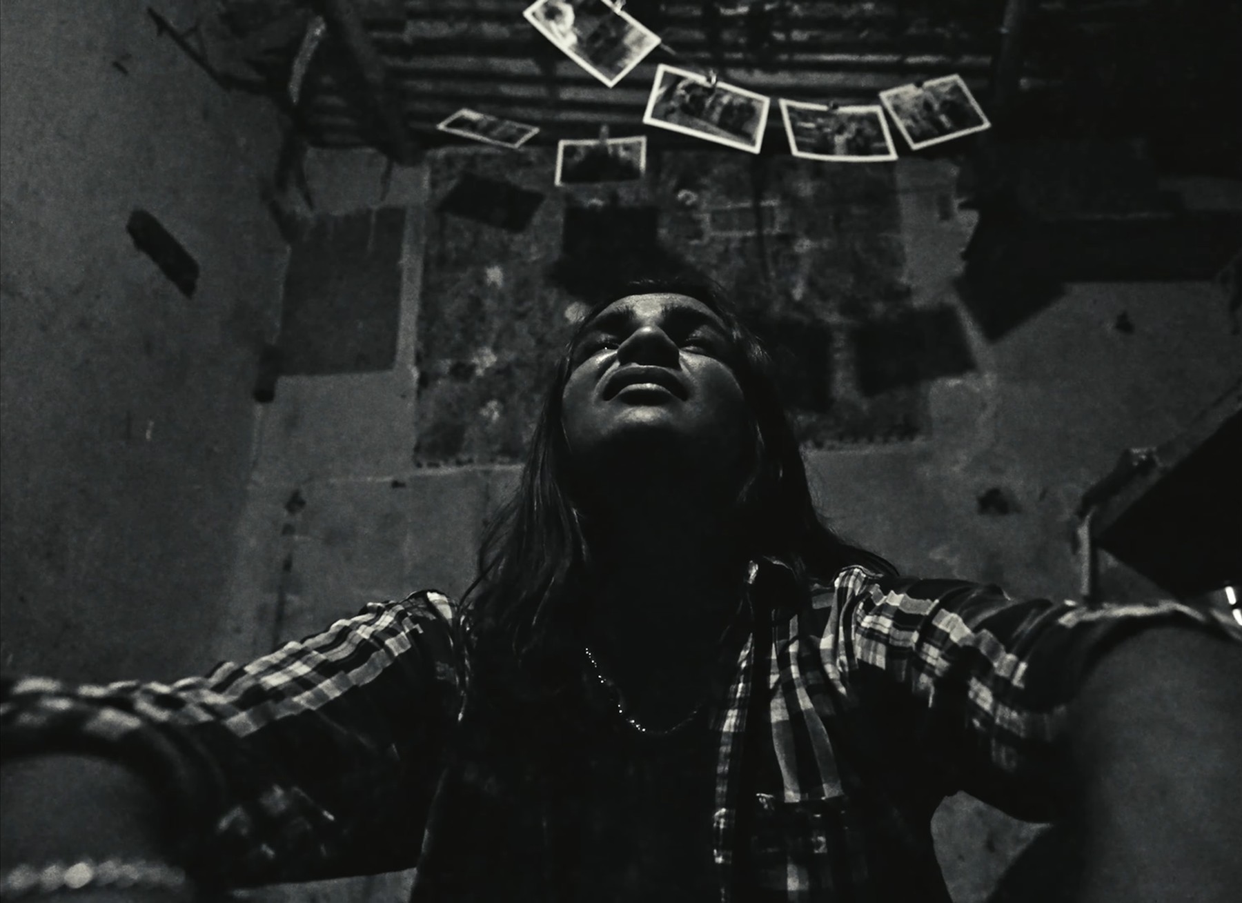 Low angle shot of a woman under hanging photographs, still from Paychecks