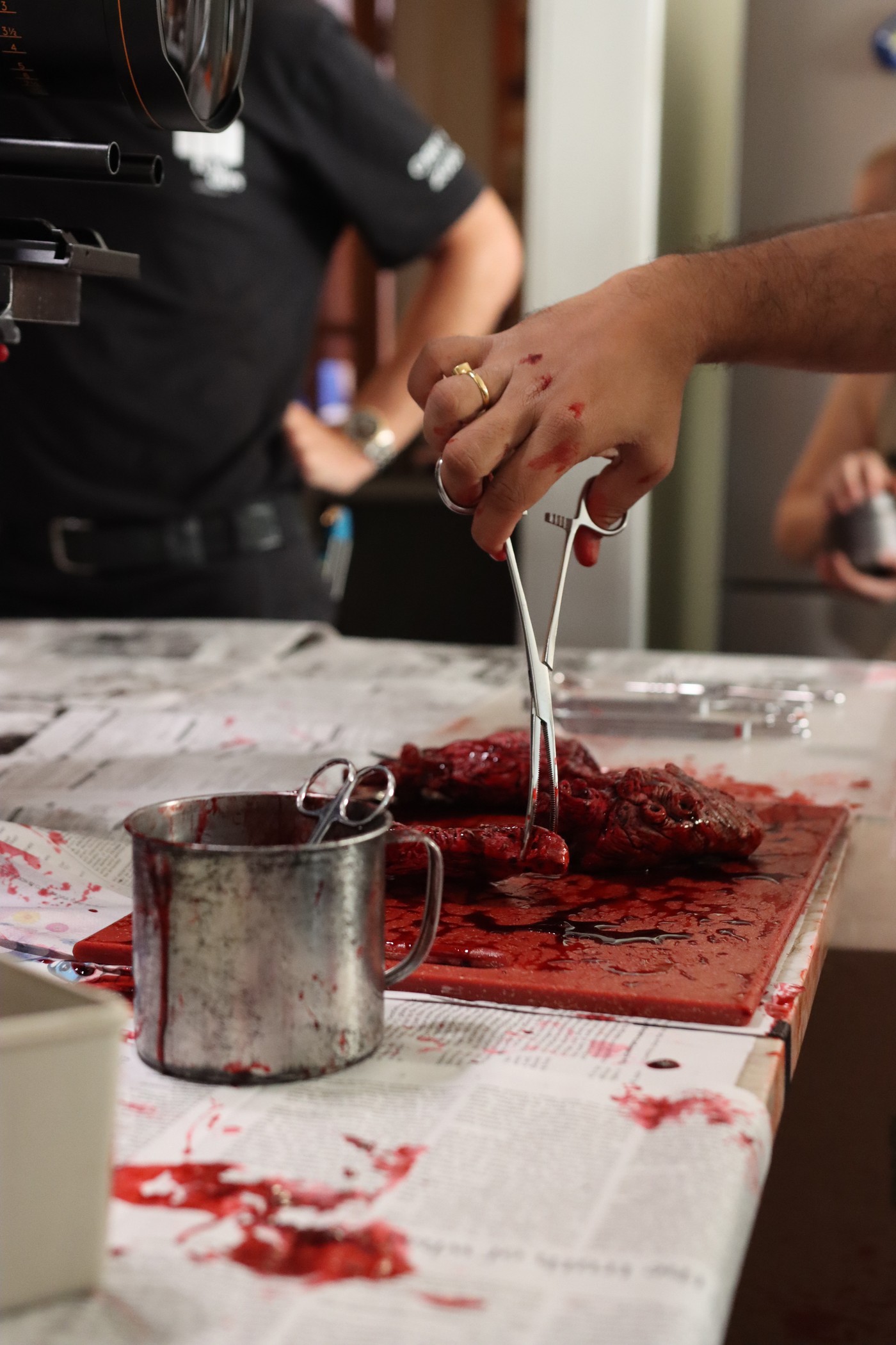 Hand holding forceps over practical gore effects