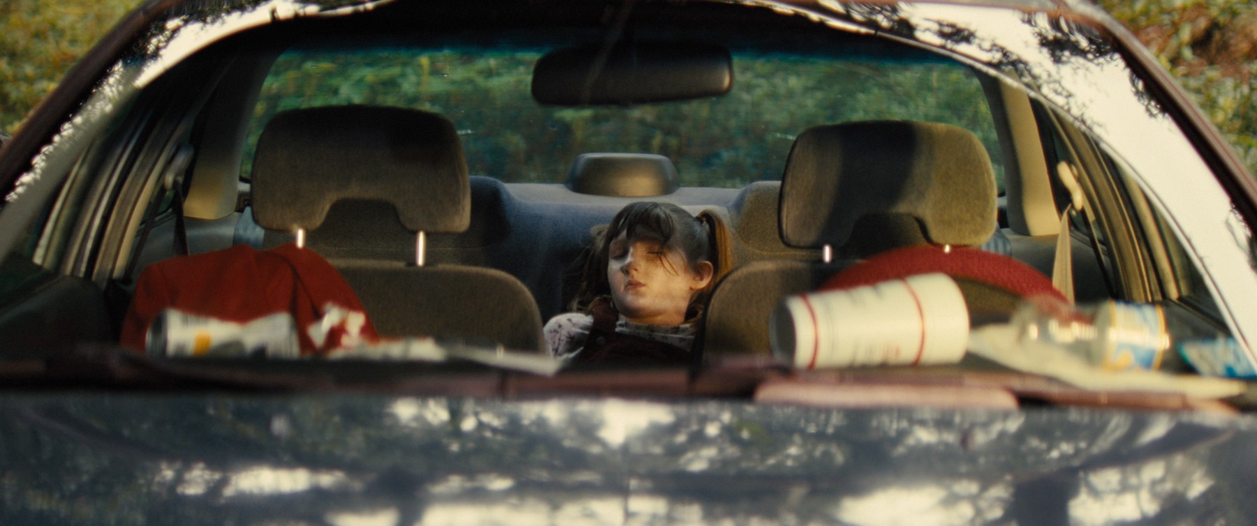 Girl slumped in the back seat of a car, still from What Are Grandchildren Made Of?