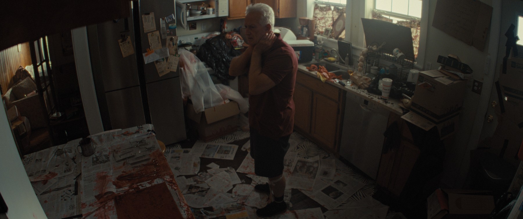 Elderly man alone in the blood-spattered kitchen
