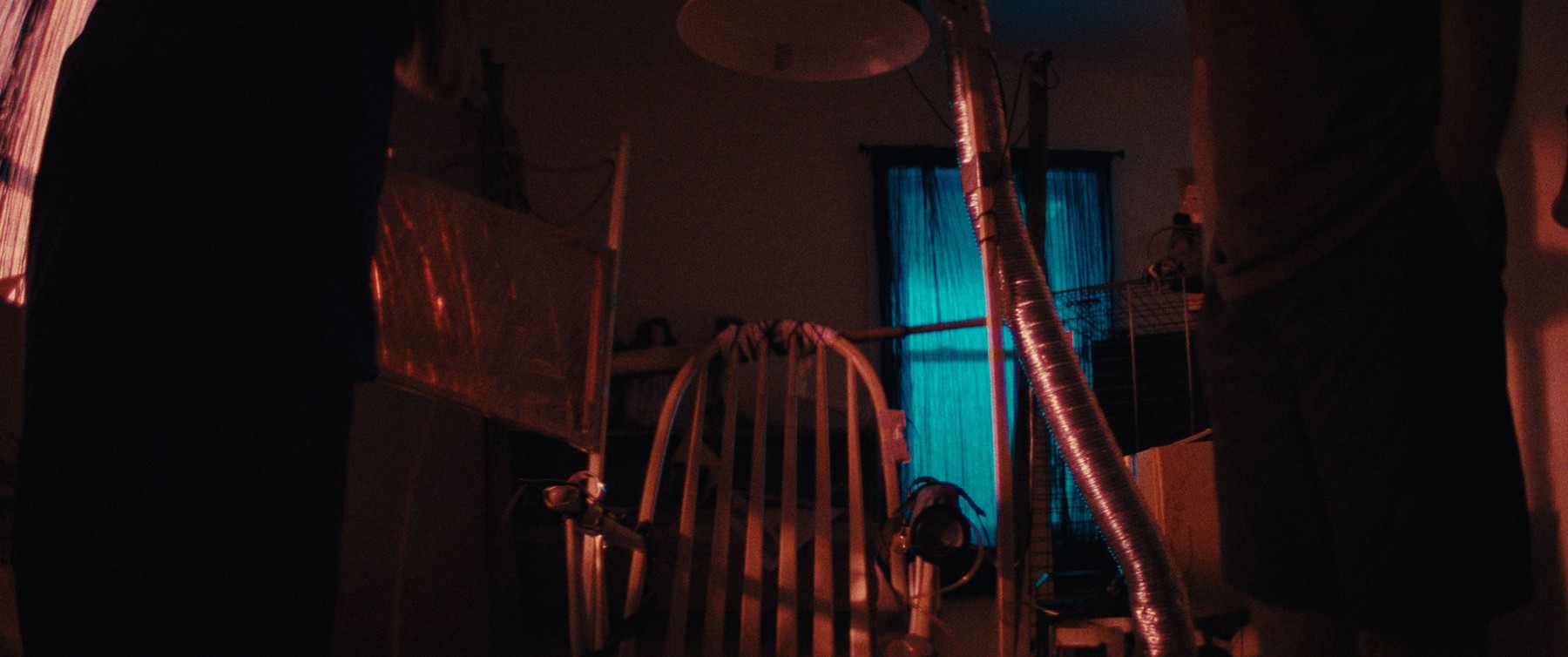 Dark room with a medical-style apparatus lit by blue window light